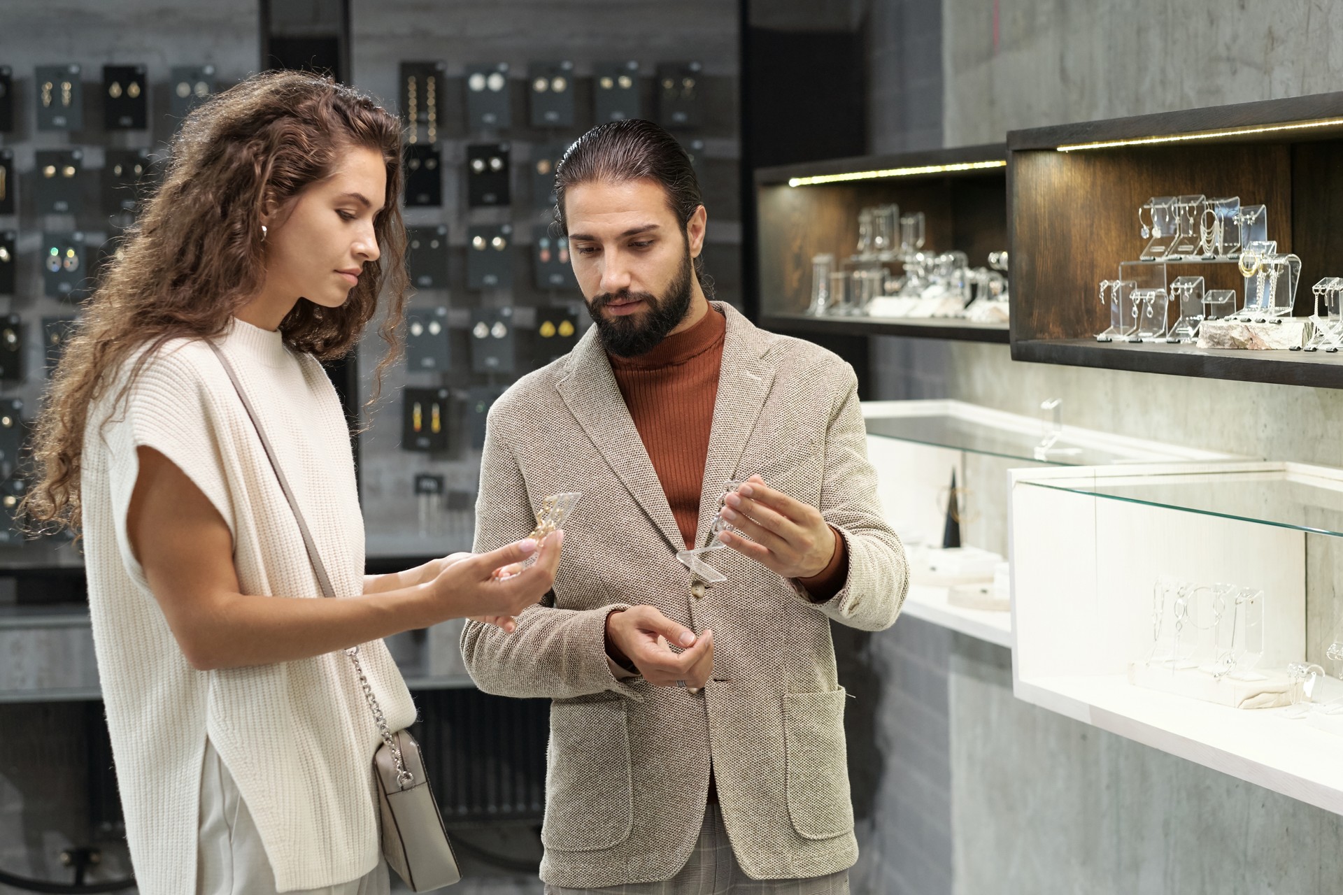 Young man and woman consulting about jewelry in boutique